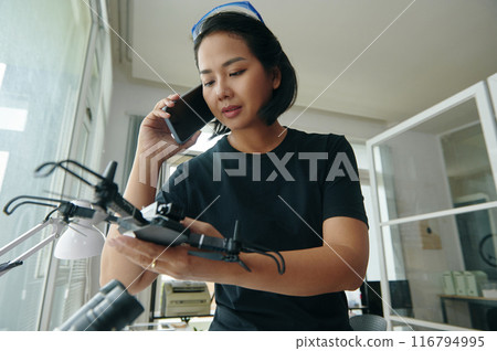 Technician Discussing Repair Of Drone With Customer Technician Discussing Repair Of Drone With Customer 116794995