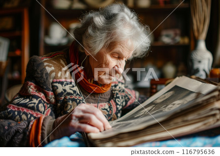 Senior Woman Reliving Memories by Browsing Through an Old Family Album 116795636
