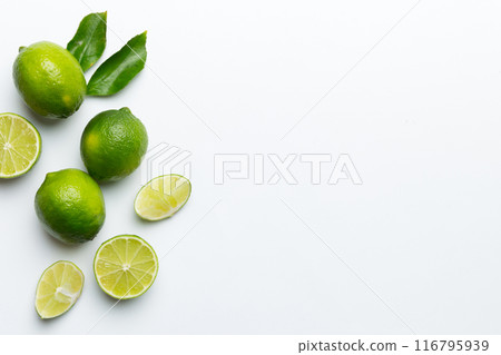 Lime fruits with green leaf and cut in half slice isolated on white background. Top view. Flat lay with copy space 116795939
