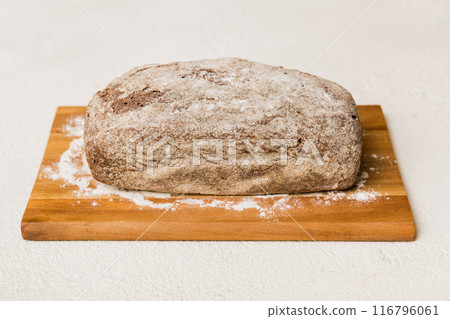 Freshly baked bread on cutting board against white wooden background. perspective view bread with copy space 116796061