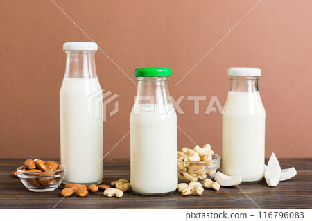 Set or collection of various vegan milk almond, coconut, cashew, on table background. Vegan plant based milk and ingredients, top view 116796083