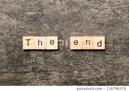 The end word written on wood block. The end text on cement table for your desing, concept The end word written on wood block. The end text on cement table for your desing, concept 116796378