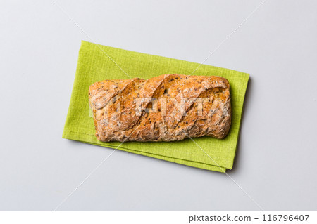 Fresh loaves of bread with wheat and gluten on a colored table. bread on napkin on rustic background, fresh bread top view Fresh loaves of bread with wheat and gluten on a colored table. bread on napkin on rustic background, fresh bread top view 116796407