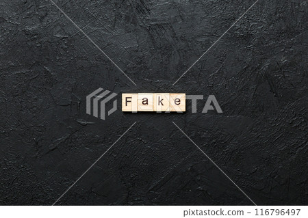 Fake word written on wood block. Fake text on cement table for your desing, concept Fake word written on wood block. Fake text on cement table for your desing, concept 116796497