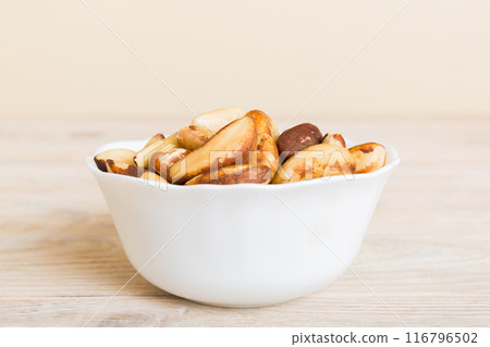 Fresh healthy Brazil nuts in bowl on colored table background. Top view Healthy eating bertholletia concept. Super foods Fresh healthy Brazil nuts in bowl on colored table background. Top view Healthy eating bertholletia concept. Super foods 116796502