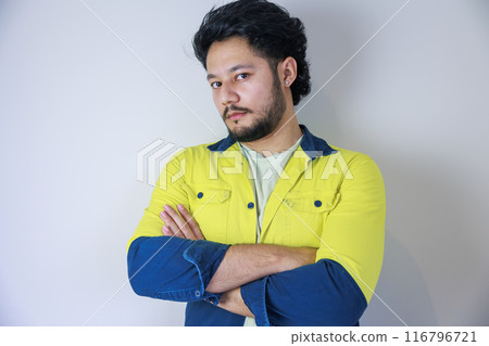 A man wearing yellow work clothes with his arms crossed A man wearing yellow work clothes with his arms crossed 116796721