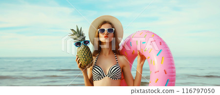 Summer vacation, tourism, happy young woman with swimming inflatable ring, pineapple on the beach Summer vacation, tourism, happy young woman with swimming inflatable ring, pineapple on the beach 116797050