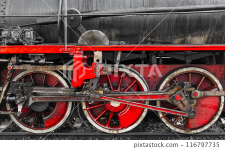 Red wheels and details of vintage black steam locomotive, close-up 116797735