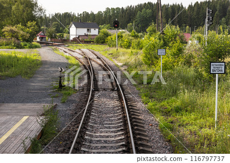 An empty railway track turning left with a railway switch An empty railway track turning left with a railway switch 116797737