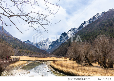 Hiker hiking in the scenic and breathtaking Yading nature reserve, located in Garze Tibetan Autonomous Prefecture, Sichuan. Hiker hiking in the scenic and breathtaking Yading nature reserve, located in Garze Tibetan Autonomous Prefecture, Sichuan. 116799643