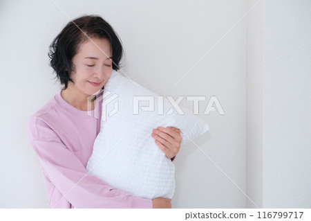 中年婦女抱著枕頭調整身心 116799717