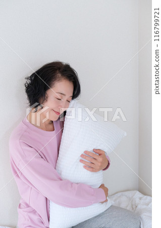 中年婦女抱著枕頭調整身心 中年婦女抱著枕頭調整身心 116799721