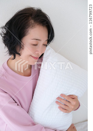 中年婦女抱著枕頭調整身心 中年婦女抱著枕頭調整身心 116799723