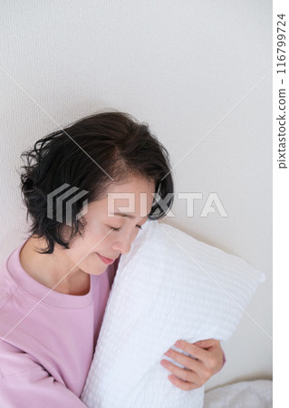 中年婦女抱著枕頭調整身心 中年婦女抱著枕頭調整身心 116799724