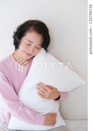 中年婦女抱著枕頭調整身心 中年婦女抱著枕頭調整身心 116799726