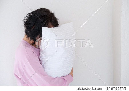 中年婦女抱著枕頭調整身心 中年婦女抱著枕頭調整身心 116799735