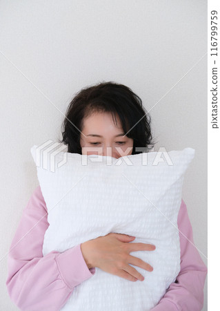 中年婦女抱著枕頭調整身心 116799759