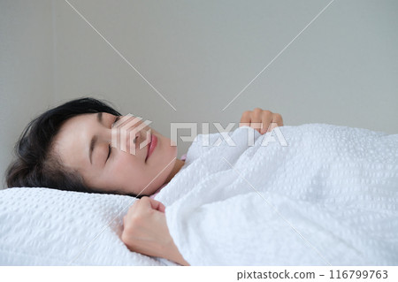 Middle-aged woman taking a nap to improve her mind and body Middle-aged woman taking a nap to improve her mind and body 116799763
