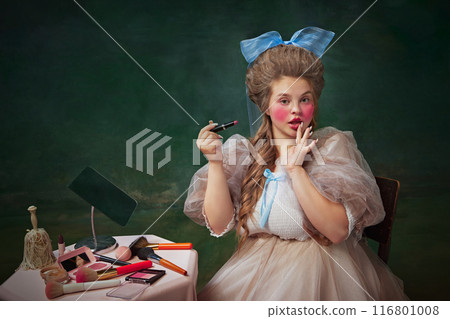 Fashion blog. Portrait of young woman with bright makeup look, applying lip gloss, against vintage green background Fashion blog. Portrait of young woman with bright makeup look, applying lip gloss, against vintage green background 116801008