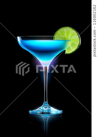 Blue cocktail glowing in the dark with a lime garnish 116802162