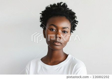 Young black woman with short curly hair posing on white background 116802202
