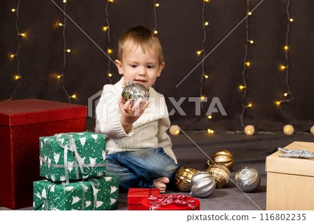 Portrait of happy little child playing with Christmas toys. Portrait of happy little child playing with Christmas toys. 116802235