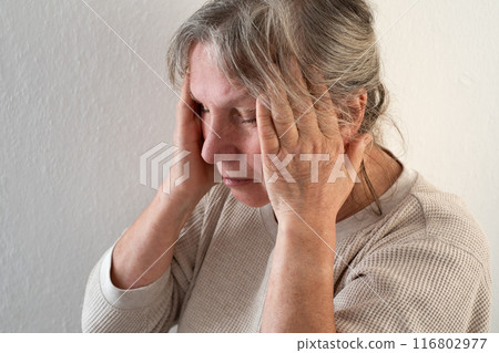 Unhappy mature woman touching head, feeling strong headache, at home alone Unhappy mature woman touching head, feeling strong headache, at home alone 116802977