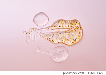 Texture of face serum, oil and serum with 24k gold on a pink background. Texture of face serum, oil and serum with 24k gold on a pink background. 116804322