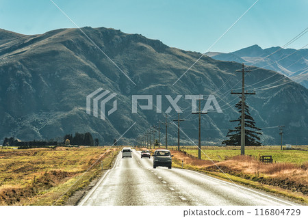 Road trip of car driving on asphalt road, country field and mountain during autumn at New Zealand Road trip of car driving on asphalt road, country field and mountain during autumn at New Zealand 116804729