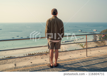Male tourist enjoying with the view of tropical sea from viewpoint on summer at Koh Larn Male tourist enjoying with the view of tropical sea from viewpoint on summer at Koh Larn 116804731