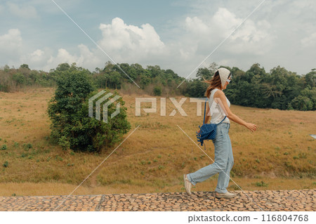 Cheerful woman walking for sightseeing the hills and fields of mountain. Cheerful woman walking for sightseeing the hills and fields of mountain. 116804768