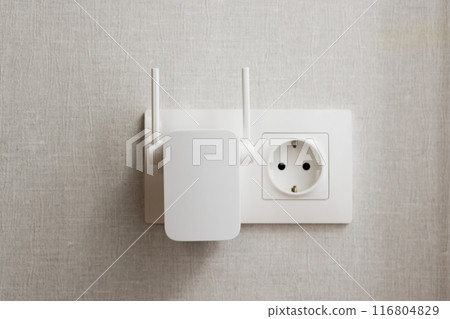 WiFi Range Extender Plugged into Wall Outlet on Textured Background WiFi Range Extender Plugged into Wall Outlet on Textured Background 116804829