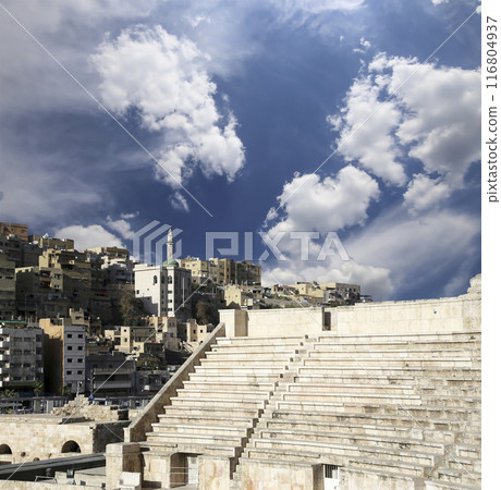 Roman Theatre in Amman, Jordan -- theatre was built the reign of Antonius Pius (138-161 CE), the large and steeply raked structure could seat about 6000 people. Against the sky with clouds Roman Theatre in Amman, Jordan -- theatre was built the reign of Antonius Pius (138-161 CE), the large and steeply raked structure could seat about 6000 people. Against the sky with clouds 116804937