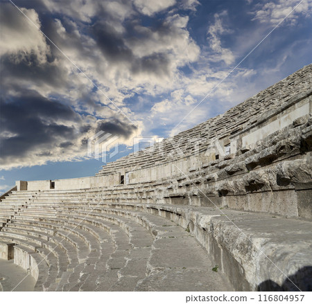 Roman Theatre in Amman, Jordan -- theatre was built the reign of Antonius Pius (138-161 CE), the large and steeply raked structure could seat about 6000 people. Against the sky with clouds Roman Theatre in Amman, Jordan -- theatre was built the reign of Antonius Pius (138-161 CE), the large and steeply raked structure could seat about 6000 people. Against the sky with clouds 116804957