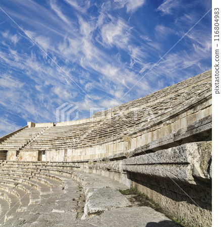 Roman Theatre in Amman, Jordan -- theatre was built the reign of Antonius Pius (138-161 CE), the large and steeply raked structure could seat about 6000 people. Against the sky with clouds Roman Theatre in Amman, Jordan -- theatre was built the reign of Antonius Pius (138-161 CE), the large and steeply raked structure could seat about 6000 people. Against the sky with clouds 116804983