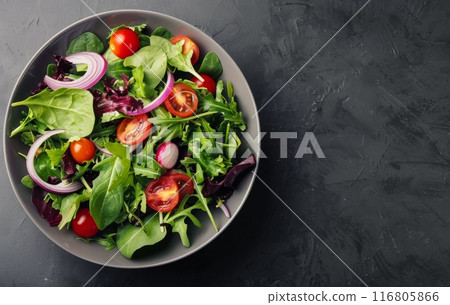 Green Salad With Tomatoes and Onions in a Black Bowl 116805866