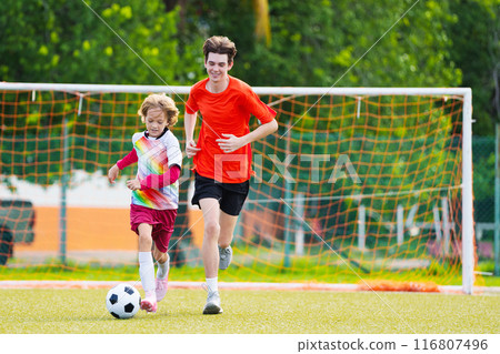 Child playing football. Kids play soccer. 116807496