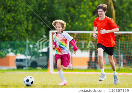 Child playing football. Kids play soccer. 116807559
