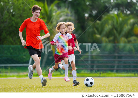 Child playing football. Kids play soccer. 116807564