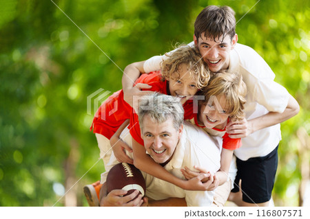 Family playing American football. Kids play rugby Family playing American football. Kids play rugby 116807571