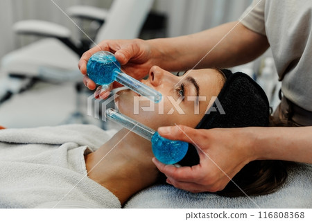 The master gives the client a relaxing facial massage using cold cryo spheres. 116808368
