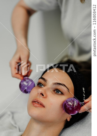 The master gives the client a relaxing facial massage using cold cryo spheres. 116808412