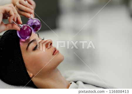 The master gives the client a relaxing facial massage using cold cryo spheres. 116808413