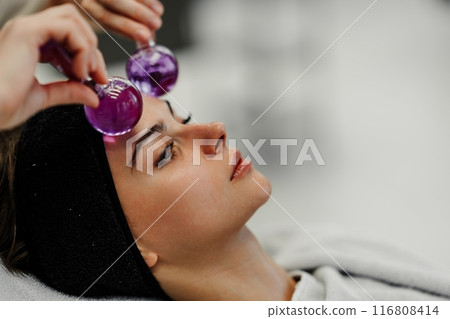 The master gives the client a relaxing facial massage using cold cryo spheres. 116808414