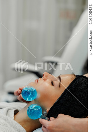 The master gives the client a relaxing facial massage using cold cryo spheres. The master gives the client a relaxing facial massage using cold cryo spheres. 116808428