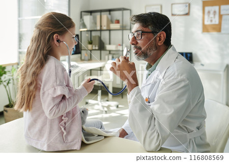 Child playing doctor with pediatrician 116808569