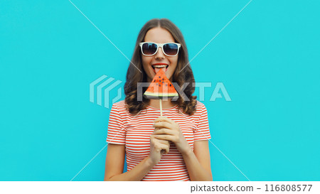 Summer portrait of happy young woman with juicy lollipop or ice cream shaped slice of watermelon 116808577