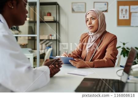 Patient in hijab listening to doctor Patient in hijab listening to doctor 116808618