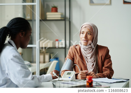 Doctor measuring patient blood pressure Doctor measuring patient blood pressure 116808623