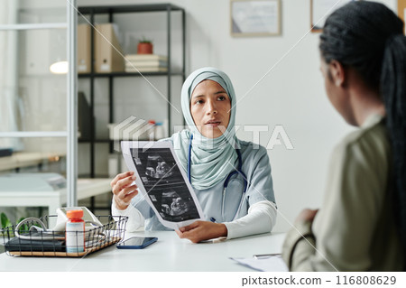 Showing sonogram to pregnant patient 116808629